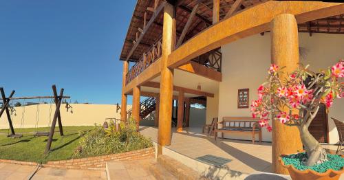eine Veranda eines Hauses mit einer Bank und Blumen in der Unterkunft Casa du Vento in Cruz