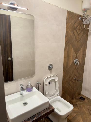 a bathroom with a sink and a toilet and a mirror at Your Ultimate Edge Awaits! in Thane