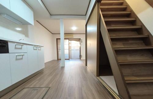 a hallway of a house with a staircase and a kitchen at Traditional Japanese architecture heiansya in Kyoto