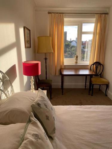 a bedroom with a bed and a desk and a window at Regis Lodge Guest House in Bognor Regis