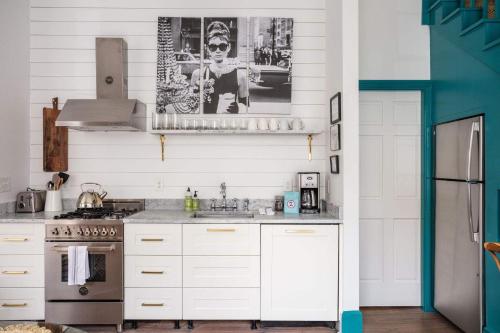 a kitchen with white cabinets and a sink at The Aviary at CasaZoe in Charleston