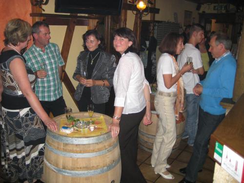 eine Gruppe von Menschen, die um ein Weinfass stehen in der Unterkunft Gasthof Pension Baumkirchner in Altheim