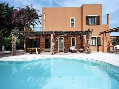 a swimming pool in front of a house at Relais Virginia Sea & Pool, Marsala in Marsala