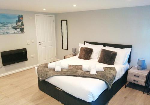a bedroom with a large bed and a television at Valkyrie in Perranzabuloe