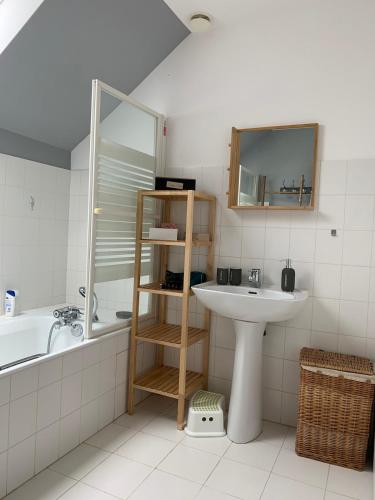 a bathroom with a sink and a tub and a mirror at Les Vendanges Maison Vigneronne in Reuilly