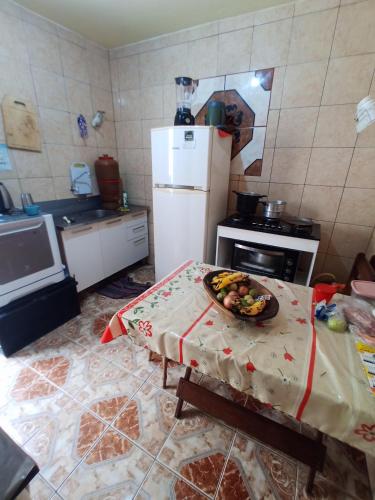 a kitchen with a table with a bowl of fruit on it at Recanto de Sol e Mar SPA in São Pedro da Aldeia