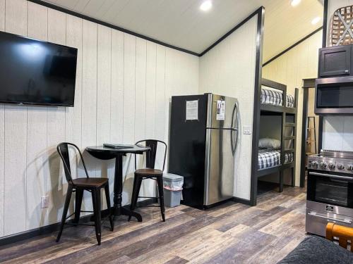a room with a refrigerator and a table and chairs at Lakefront Cabin - The Willows - 11 in Mead