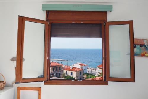 a window with a view of the ocean at Atlantis Rooms in Ágios Konstantínos