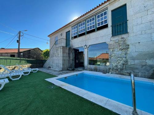 a swimming pool in the backyard of a house at Casa do Capitão de Cutelo - Gerês in Terras de Bouro