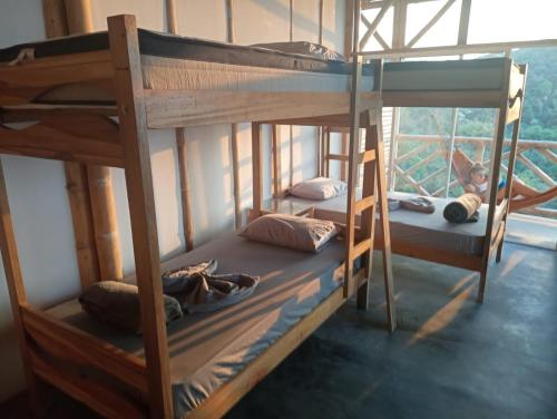 two bunk beds in a room with a window at Rancho de la luna in Minca