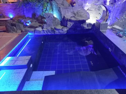a pool with blue lights in a room with rocks at Air Luxury in Terzigno