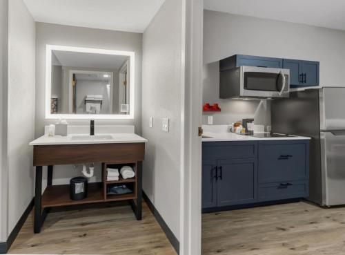 a kitchen with blue cabinets and a sink at Hawthorn Extended Stay by Wyndham College Station in College Station