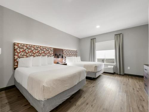 a hotel room with two beds and a window at Hawthorn Extended Stay by Wyndham College Station in College Station