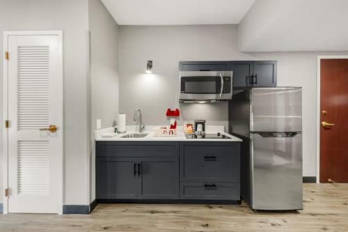a kitchen with a sink and a refrigerator at Hawthorn Extended Stay by Wyndham College Station in College Station