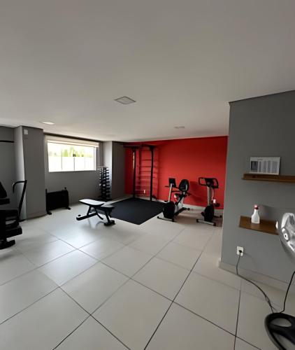 a large room with a gym with a table and chairs at Charmoso e tecnológico! Piscina panorâmica! in Sorocaba