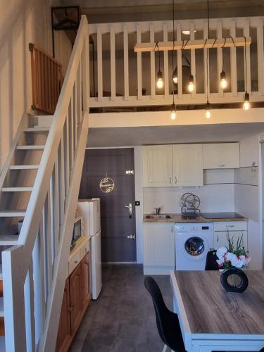 une cuisine avec des armoires blanches et un escalier dans une cuisine dans l'établissement Vue magnifique, Appt 5 couchages, Clim, Secteur Lydia Grande Plage, au Barcarès