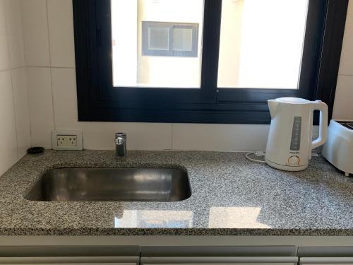 a kitchen counter with a sink and a coffee maker at OH! Bahia Depto con cochera FREE in Bahía Blanca