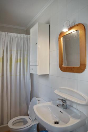 a bathroom with a sink and a toilet and a mirror at Adosado La racona, Las Rotas de Denia in Denia