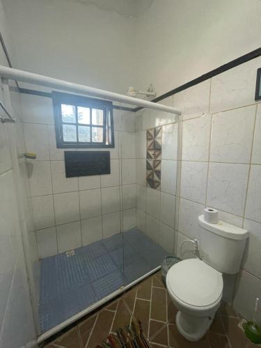 a bathroom with a shower with a toilet and a window at Recanto da Praia Rasa in Búzios