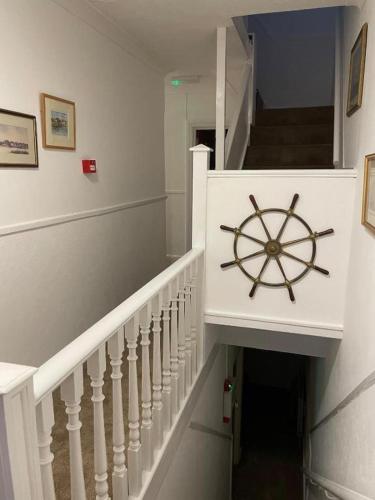 a stairway with a wooden steering wheel on the wall at Regis Lodge Guest House in Bognor Regis