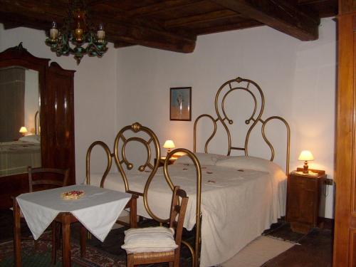 1 dormitorio con 1 cama con mesa y sillas en B&B Le Limentre en San Pellegrino al Cassero