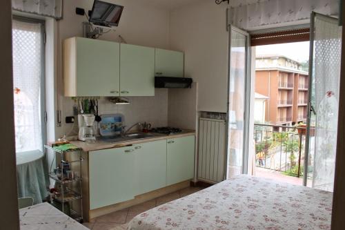 バルドリーノにあるStella Angelaの白いキャビネットと大きな窓付きのキッチン