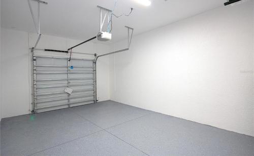 an empty room with a metal garage door at New home near beautiful beaches in Port Charlotte