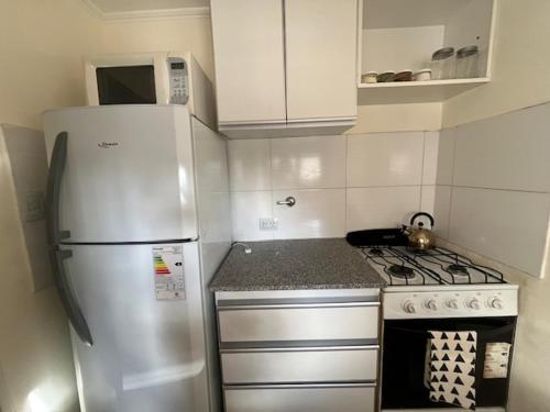 a small kitchen with a refrigerator and a stove at OH! Bahia Depto con cochera FREE in Bahía Blanca