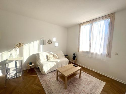 un salon blanc avec un canapé et une table dans l'établissement Studio lumineux, cosy et calme - Nice, à Nice