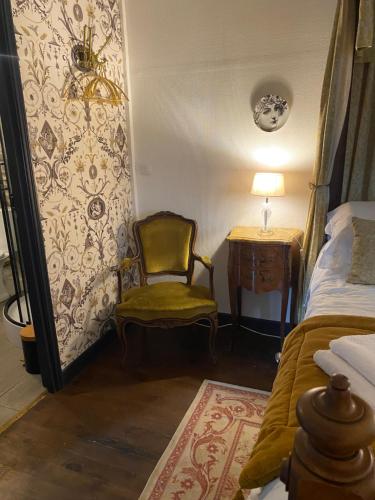 a bedroom with a chair and a bed and a table at Moon River Bellac Chambre d'hotes in Bellac