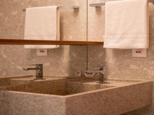 two sinks in a bathroom with white towels at Salinas Premium Resort in Salinópolis