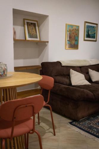 a living room with a brown couch and a table at Casa Cavour in Tarquinia