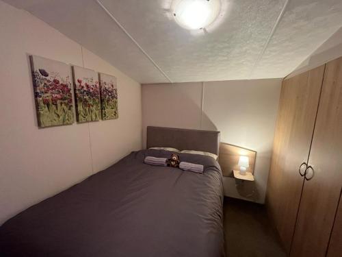 a small bedroom with a bed and two paintings on the wall at The Getaway Billing Aquadrome in Great Billing