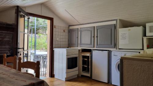 Elle comprend une petite cuisine avec des appareils électroménagers blancs et une fenêtre. dans l'établissement Location cap corse, à Canari