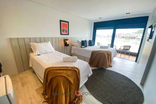 a hotel room with two beds and a balcony at BALUARTE POUSADA in Torres