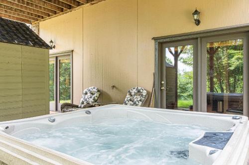 a large bath tub in a room with chairs at Tatanka at LakeLure Rumbling Bald Hot Tub Fire Pit in Lake Lure