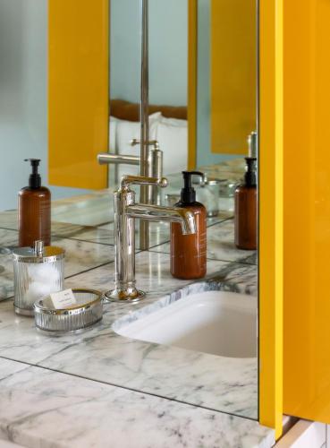 a bathroom counter with a sink and a mirror at Hotel Saint Augustine in Houston
