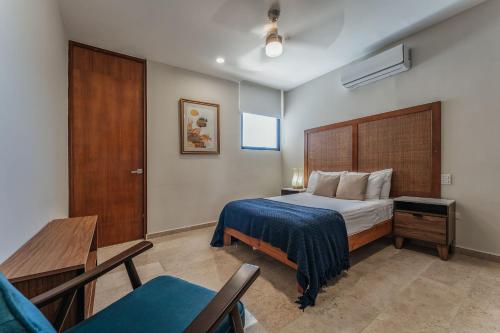 a bedroom with a bed and a table and a chair at Zirene, Depto con jacuzzi priv in Chicxulub
