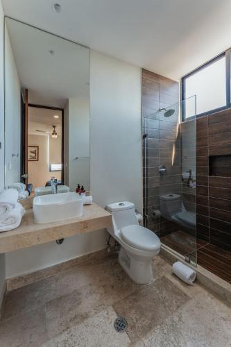 a bathroom with a toilet and a sink and a shower at Zirene, Depto con jacuzzi priv in Chicxulub