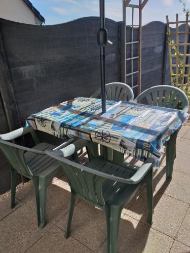 une table et des chaises avec une nappe en haut dans l'établissement Les Azalées, à Folligny