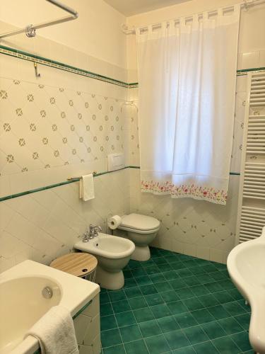 a white bathroom with a toilet and a sink at Casa vacanze - I due ulivi- passignano sul Trasimeno in Passignano sul Trasimeno