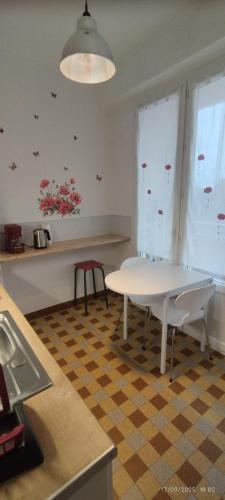 une cuisine avec une table blanche et une fenêtre dans l'établissement Joli F1 au coeur de Paray, à Paray-le-Monial