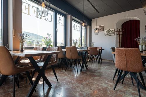 a dining room with tables and chairs and large windows at Moselresidenz Bellevue Alf in Alf