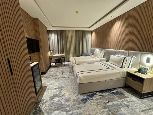 a hotel room with two beds and a television at فندق هيل Hill Hotel in Al Madinah