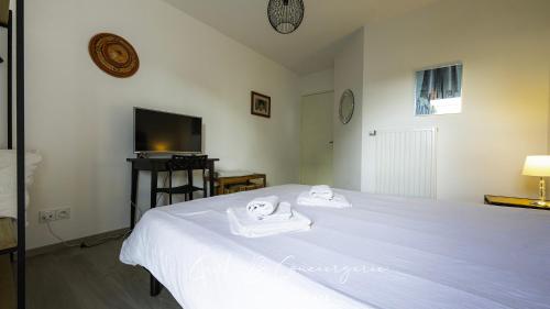 une chambre avec un lit blanc avec des serviettes dessus dans l'établissement 