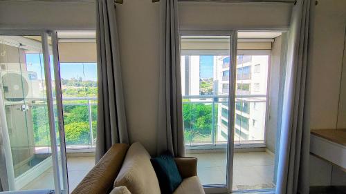 a living room with a couch and two windows at FLATS - DUO JK in Sao Jose do Rio Preto