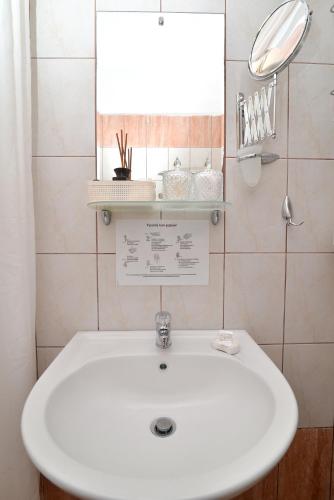 a white sink in a bathroom with a mirror at Εlvina apartments in Leptokaria