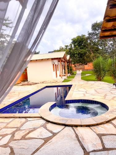 una piscina en un patio con una casa en CHACARA da LARY, en Pirenópolis