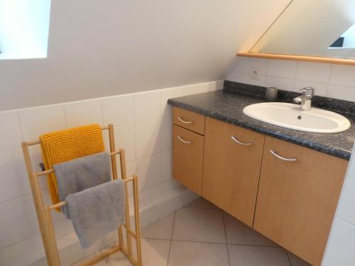 La salle de bains est pourvue d'un lavabo et d'un sèche-serviettes. dans l'établissement LE BRIDGE, à Bénouville