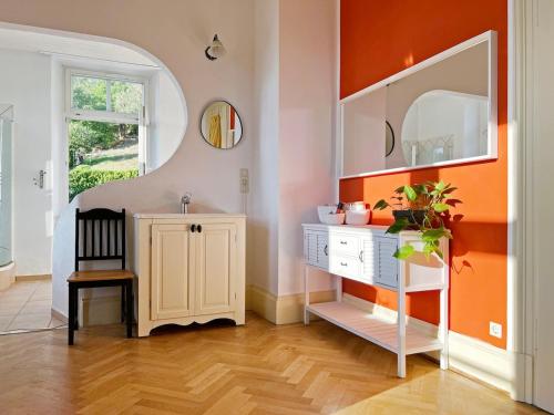 a bathroom with a white vanity and an orange wall at theMAP in Lenzkirch